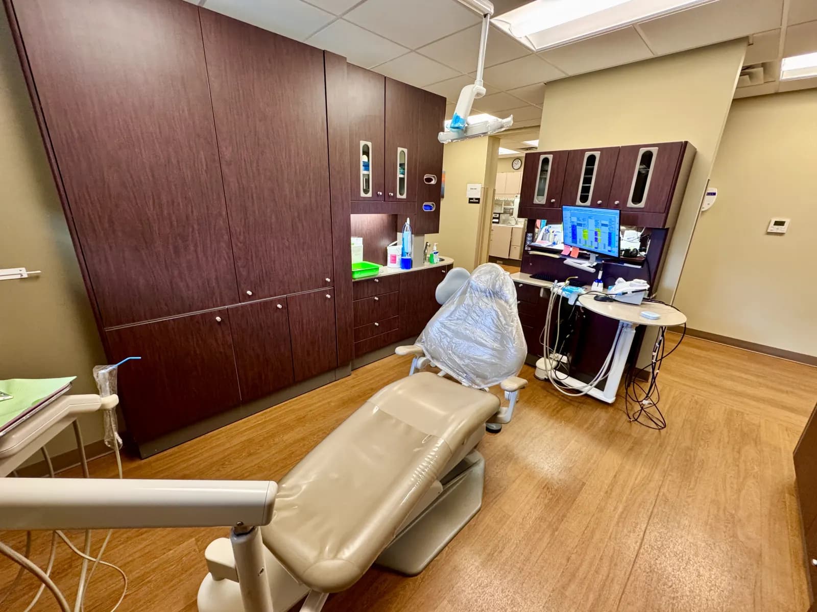 An empty dental treatment room with a dental chair and instruments.