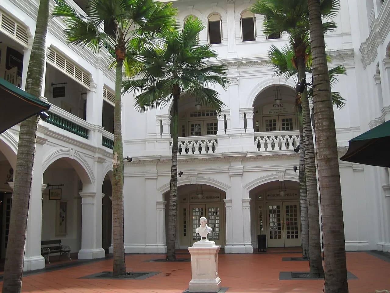 The palm-lined courtyard and white arcades of Raffles Hotel in Singapore.