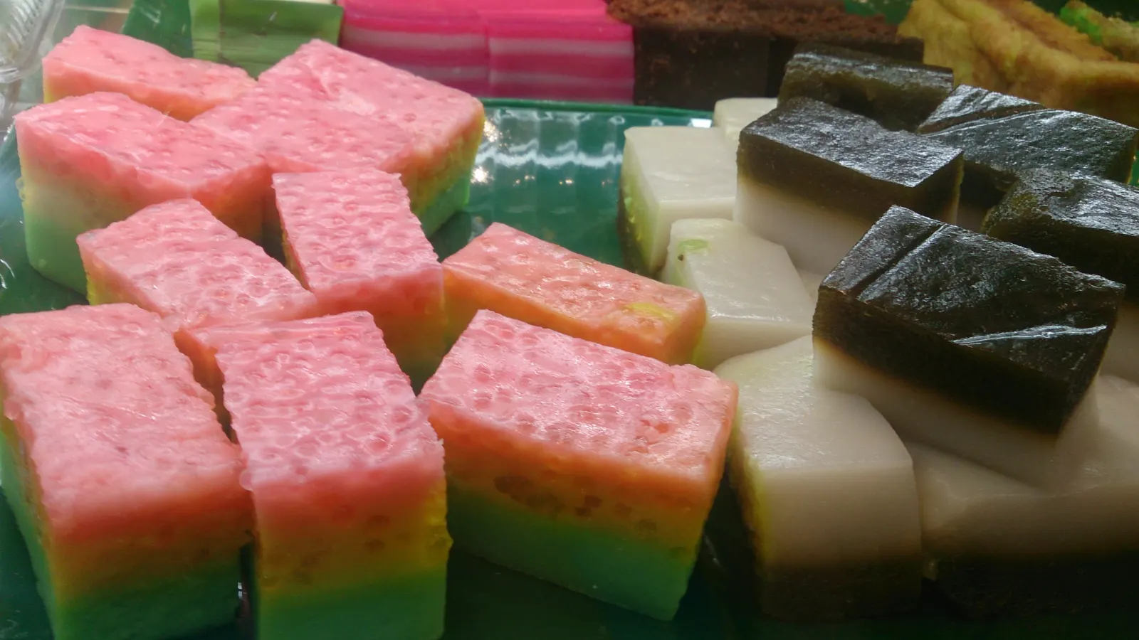 Colourful nonya kueh arranged on a plate in Singapore.