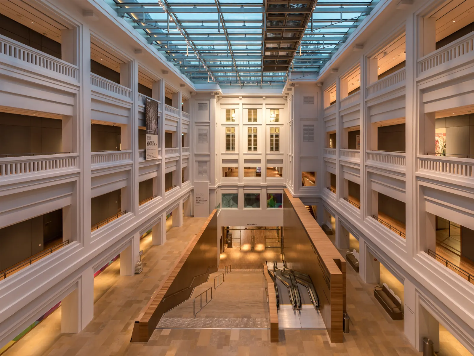 Multi-level interior of National Gallery Singapore with corridors and escalators.
