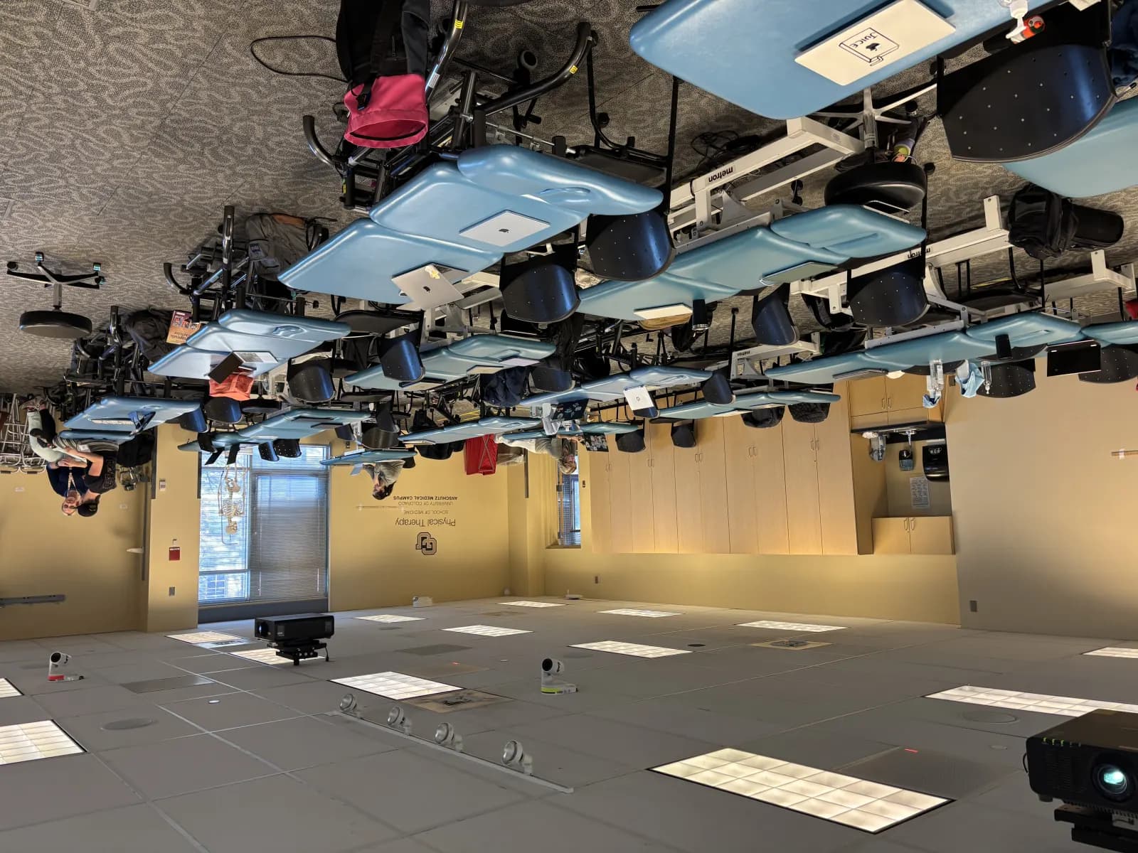 A physical therapy teaching lab with treatment tables and rehabilitation equipment.